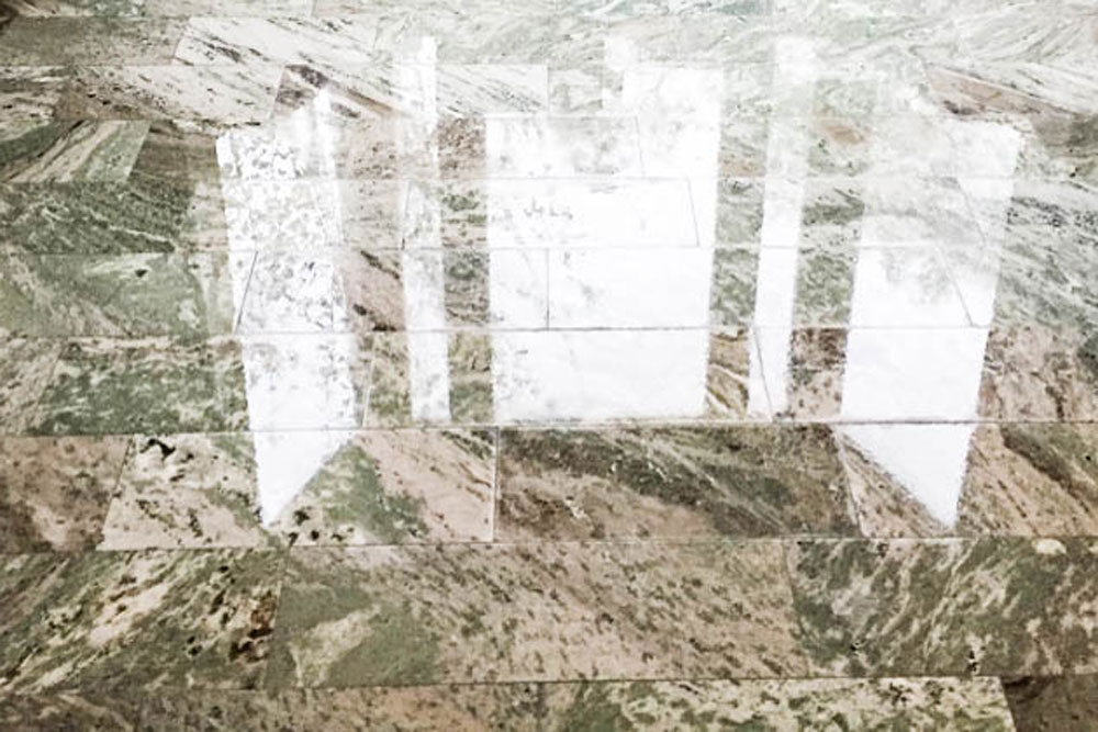 Blankpolerat golv i natursten med tydliga ljusreflektioner